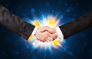 Two business men shaking hands with a successes agreement with explosion